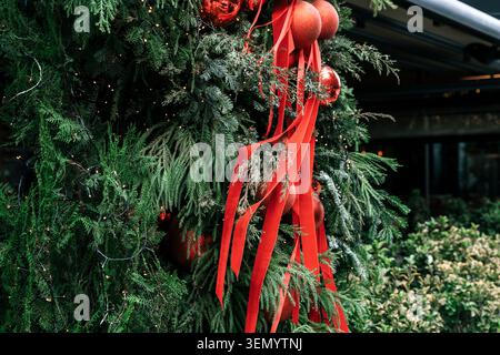 Sapin de Noël festif décoré de boules et de rubans rouges. Photo de haute qualité Banque D'Images