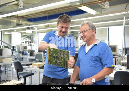 Travail d'équipe dans l'industrie - travailleur senior et jeune dans le département d'ingénierie d'une usine pour la production et la construction de l'électronique Banque D'Images