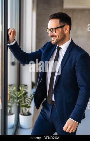 Portrait d'un bel homme d'affaires réussi debout dans un bureau d'entreprise moderne Banque D'Images