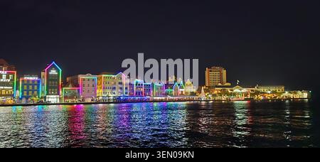 Des lumières de Noël illuminent les bâtiments colorés du bord de mer de Handelskade à Punda, Willemstad, Curaçao, avec des reflets chatoyants à travers toute la gamme Ann Banque D'Images