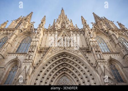 Façade gothique de la cathédrale avec des arches et des flèches ornées contre un ciel bleu clair. Banque D'Images