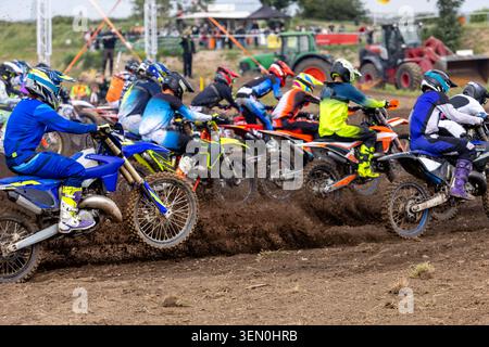 Motocross vue rapprochée sur les motos tout terrain avant de commencer la course compétitive en plein air. Machines recouvertes de boue équipement de protection créé par les athlètes Banque D'Images