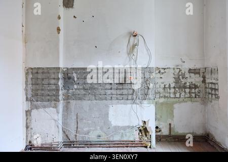 Cela capture un intérieur d'appartement vide dans un ancien bâtiment de Berlin, Prenzlauer Berg, avant rénovation. La scène montre des murs endommagés avec exposés Banque D'Images