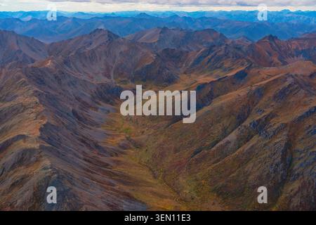 Vue aérienne de la chaîne de montagnes accidentée avec des couleurs d'automne sous un ciel expansif. Banque D'Images