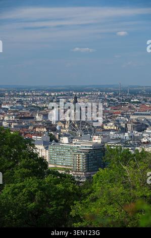 Budapest, Hongrie - 31 mai 2026 : vue en angle élevé de la ville de Pest avec la basilique Stephens et la grande roue s'élevant au-dessus des arbres verts. Banque D'Images