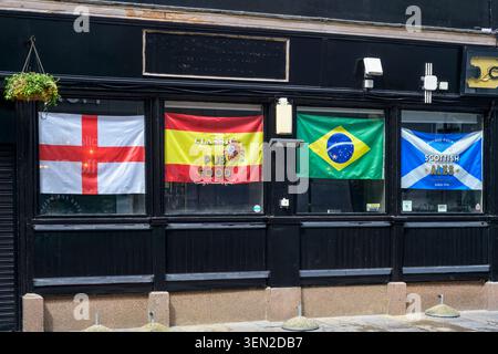 Angleterre, Espagne, Brésil et Ecosse drapeaux dans une vitrine de pub décorée pour la Coupe du monde 2026, Glasgow, Ecosse, Royaume-Uni Banque D'Images