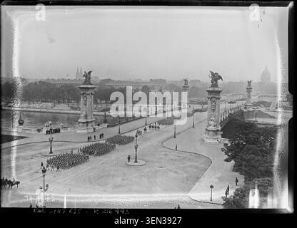 Le 14 juillet 1930, des unités militaires défilent le long de l'avenue Alexandre III à Paris, observées depuis le toit du Grand Palais avec une vue dégagée sur le pont Alexandre III. Banque D'Images