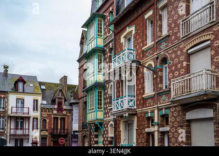 Une vue urbaine montre des bâtiments historiques aux façades en briques rouges à mers-les-bains. Il dispose d'une baie vitrée verticale de trois étages peinte en jaune et en t Banque D'Images