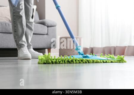 Personne nettoyant le sol de la maison avec une serpillère en microfibre, les tâches ménagères et la routine de nettoyage domestique, équipement de nettoyage moderne Banque D'Images