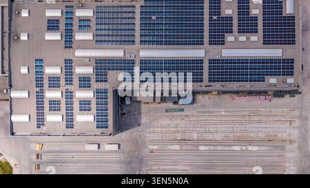Vue de dessus aérienne du toit d'entrepôt industriel avec panneaux solaires et système d'énergie durable Banque D'Images