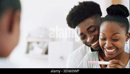 Sourire, couple noir et test de grossesse en maison avec miroir, résultats positifs et succès de fiv. Réflexion, personnes ou câlin matinal avec kit de fertilité Banque D'Images