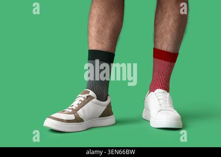 Chaussettes et baskets inégalées sur les jambes masculines, individualité et style unique, choix de la mode et expression personnelle Banque D'Images