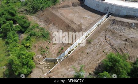 Une vue aérienne de haut en bas d'un canal de drainage en béton nouvellement construit et d'un système de contrôle des inondations dans une zone de développement industriel indonésien. Banque D'Images