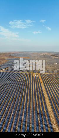 Drone vue aérienne d'une vaste ferme solaire avec des milliers de panneaux photovoltaïques sous ciel bleu. Énergies renouvelables, durabilité, électricité propre. Banque D'Images