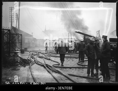 Les pompiers assistent à un incendie d'usine à Aubervilliers sur cette photo de presse. Le registre du catalogue identifie les pompiers, les usines et les incendies à Aubervilliers, documentant une scène d'urgence industrielle. Banque D'Images