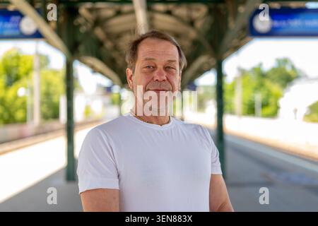 Homme debout sur la plate-forme ferroviaire. Banque D'Images