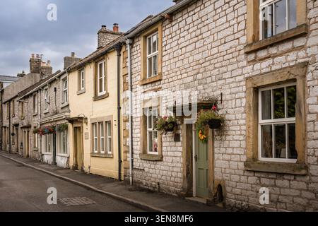 Vue architecturale détaillée regardant le long des façades, des fenêtres en pierre et des portes en bois vert de chalets historiques en calcaire sur Church Street à Tidesw Banque D'Images