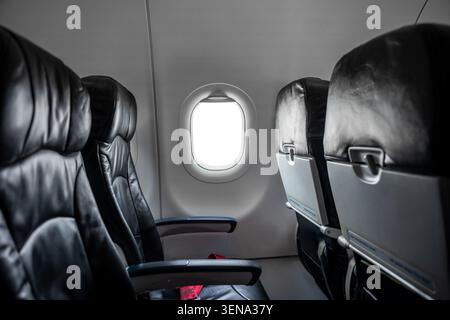 Intérieur de la cabine d'avion, sièges passagers confortables vides en classe économique avec hublots. Banque D'Images