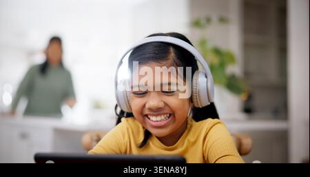 Écouteurs, lecture et enfant avec tablette à la maison, éducation en ligne et regarder en direct streaming de la classe. Rire, elearning et fille heureuse avec technologie pour Banque D'Images