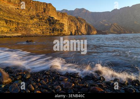 Coucher de soleil doré sur les falaises volcaniques et Rocky Shore près de Puerto de las Nieves, Gran Canaria, Îles Canaries, Espagne Banque D'Images