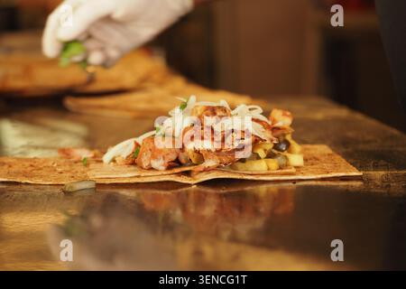 préparation d'un wrap de poulet ou shawarma dans un cadre de restaurant. Banque D'Images