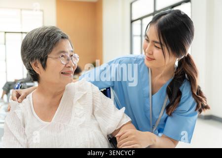 Femme âgée sourire aux médecins et aux infirmières de l'hôpital. homme senior heureux après avoir reçu le traitement et les soins et la pratique marcher d'un professionnel Banque D'Images