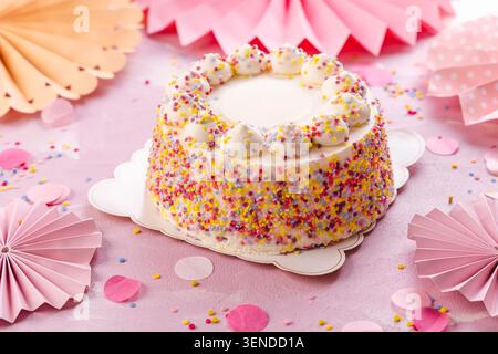 Délicieux gâteau crème pour fête d'anniversaire avec des décorations en papier rose Banque D'Images