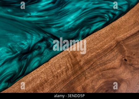 Détail de table de rivière de luxe avec résine époxy émeraude et bois de noyer naturel Banque D'Images