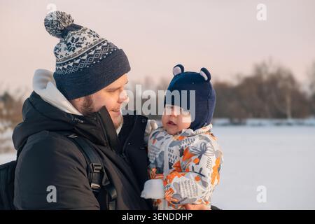 Père et bébé Bonding dans la scène hivernale Banque D'Images