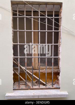 Travaux de rénovation de bâtiments montrant un cadre de fenêtre enlevé avec du plâtre manquant et des briques apparentes, des barres de métal restant sur l'habitation pendant la construction i Banque D'Images