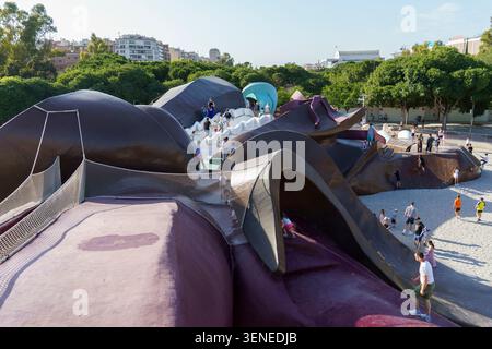 Enfants et familles jouant sur le toboggan sculpté géant du parc Gulliver à Valence, Espagne Banque D'Images