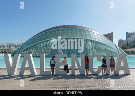 Groupe de jeunes femmes touristes posant devant le grand panneau Valence à la Cité des Arts et des Sciences de Valence, Espagne Banque D'Images