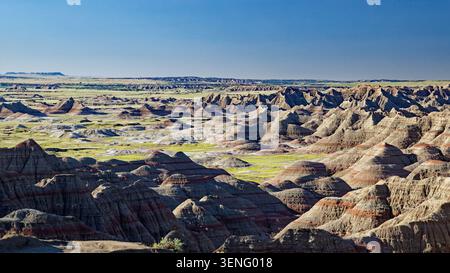 Vue imprenable sur le terrain accidenté et érodé du parc national des Badlands dans le Dakota du Sud, présentant des formations rocheuses en couches et une végétation clairsemée Banque D'Images