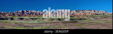 Une large vue panoramique sur les formations géologiques spectaculaires et le paysage érodé du parc national des Badlands sous un ciel bleu clair Banque D'Images