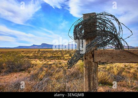 Poteau de clôture en fil de fer barbelé et paysage du désert de l'Arizona sous ciel bleu Banque D'Images