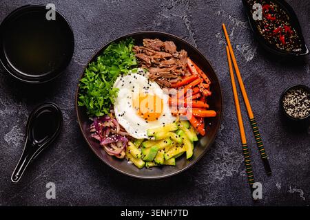Plat traditionnel coréen Bibimbap : riz aux légumes, boeuf et oeuf, vue de dessus. Banque D'Images