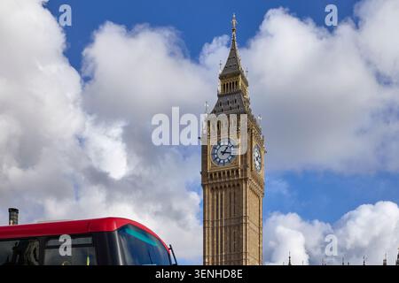 Elizabeth Tower debout avec un bus à impériale rouge passant par un jour nuageux lumineux Banque D'Images