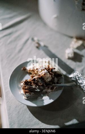 Tranche de gâteau de mariage sur plaque blanche avec fourchette Banque D'Images