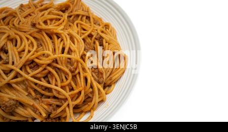 Photographie culinaire minimale de spaghettis maison à la bolognaise servis sur une assiette blanche ordinaire, présentation propre sans herbes ni garniture supplémentaire. Banque D'Images