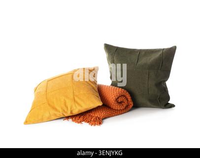 Arrangement de décoration de maison confortable avec des oreillers jaune moutarde et vert olive et une couverture tricotée orange roulée, les textiles présentent des textures distinctes et Banque D'Images