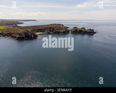 Un plan grand angle capture la majestueuse péninsule de la pointe de Dinan. Les falaises accidentées forment une arche rocheuse naturelle s'étendant dans le calme, paillettes Banque D'Images