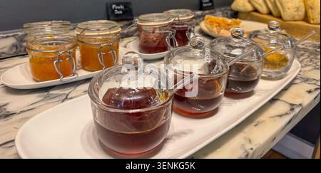 une sélection de confitures et de miel dans des bocaux sur un comptoir en marbre concept de petit déjeuner buffet Banque D'Images