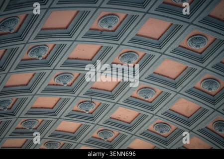 Cette image capture une vue rapprochée d'un plafond orné et incurvé à caissons, présentant des motifs géométriques répétitifs et des médaillons circulaires décoratifs. Banque D'Images
