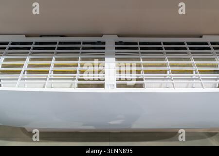 L'unité de climatisation montée au plafond est présentée dans un cadre industriel lumineux. Les tuyaux et les systèmes de ventilation sont visibles autour de l'unité, soulignez Banque D'Images