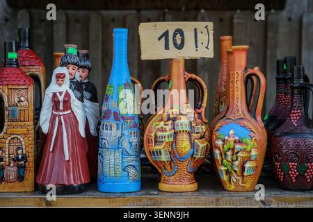 Une vue rapprochée révèle une gamme de souvenirs en céramique géorgienne traditionnels colorés, y compris des récipients à vin décorés et des figurines en costum national Banque D'Images