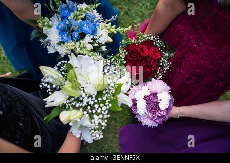 Demoiselles d'honneur en robes colorées tenant leurs bouquets Banque D'Images