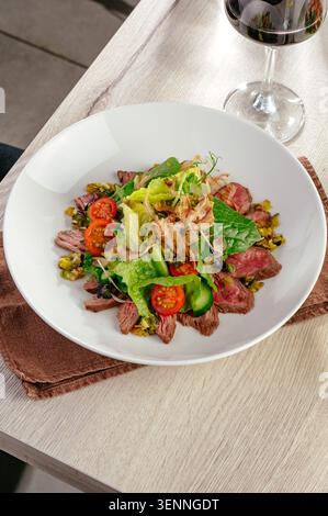Salade de steak gastronomique avec légumes verts frais et vin Banque D'Images