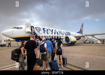 Passagers embarquant sur un vol Ryanair à l'aéroport Marrakech-Menara, Maroc. Maroc, Marrakech - 12 août 2023 : un groupe de passagers attendant de monter à bord d'un avion Ryanair sur le tarmac de l'aéroport RAK de Marrakech-Menara. Les voyageurs sont vus avec leurs bagages près des escaliers de l'avion sous un ciel nuageux. Marrakech Maroc Copyright : xGennaroxLeonardix Banque D'Images