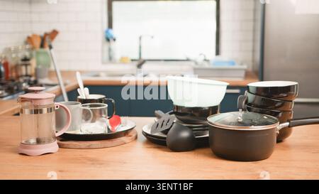 Vaisselle sale et batterie de cuisine empilée sur le comptoir de cuisine à côté de la presse française et des verres Banque D'Images