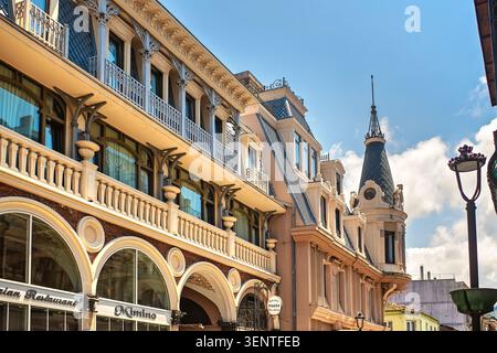 Batumi, Géorgie - 09 juin 2026 : façade de bâtiment élégante sur la Piazza Square avec de beaux balcons, colonnes, entrée du restaurant et tour d'angle. Banque D'Images